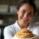 Sofía Hernández, Chef de Repostería de Café Lumina, mostrando una bandeja de pan dulce recién horneado.